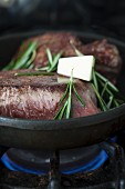 Steak with rosemary and butter in a frying pan