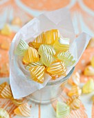 Yellow and white striped bonbons in a glass