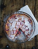 Rhubarb cake in a baking tin on a wooden table