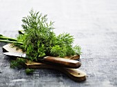 Dill on a wooden chopping board with a knife