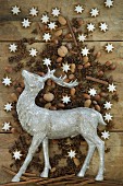 Stag figurine surrounded by nuts, cinnamon stars, cinnamon sticks and star anise