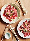 Two plates of Wagyu beef carpaccio with horseradish