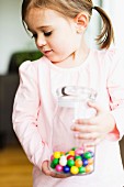 A little girl holding a jar of sweets