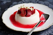 Panna cotta with rhubarb coulis garnished with elderflowers