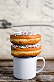 Doughnuts with sugar sprinkles on top of a coffee cup