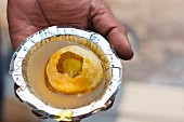 Indischer Mann einen Golgappa in der Hand haltend (Gefüllte Brotkugel, Indien)