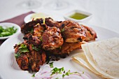 Fried tandoori chicken with onions and unleavened bread
