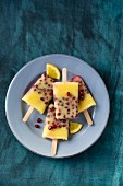 Four orange and pomegranate ice lollies on a plate