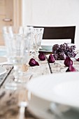 An autumnal laid table with wine glasses and purple flowers