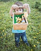 A little boy holding up his Easter basket of chocolate bunnies