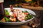 A mixed salad with grilled gammon, pears, strawberries, goat's cheese, crispy ham, hazelnuts and maple vinaigrette
