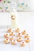 Mini Bundt cakes and a bottle of milk on a white wooden table