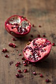 A halved pomegranate on a wooden surface