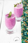 Two glasses of pink berry smoothie with mint