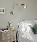 Tolomeo wall lamp and shabby-chic bedside cabinet next to double bed
