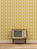 Retro TV against yellow patterned wallpaper