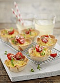 Scrambled eggs with diced ham in pastry cups garnished with tomatoes and cress