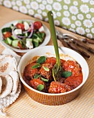Keftedes in tomato sauce served with a Greek salad