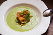 Cream of pea soup with croutons and tomatoes