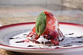Lava cake with a scoop of ice cream, berry sauce and mint leaf