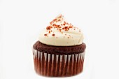 A Red Velvet cupcake decorated with cream and crumbs