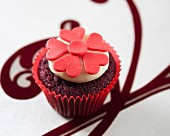 Red Velvet Cupcake mit roter Fondant-Blüte