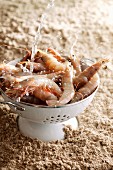 King prawns in a colander with a stream of water