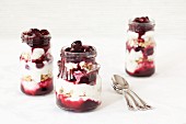 Three jars of yoghurt muesli with cherry compote and cereals