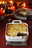 Shepherd's pie, with a portion missing, and two glasses of red wine (Christmas)