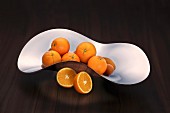 Oranges in a curved stainless steel dish