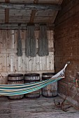 Hammock hanging from hook in rustic wooden wall