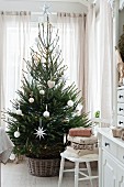 Christmas tree with white decorations in front of window