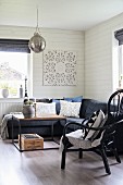 Corner couch and cane chair around coffee table in wood-clad living room