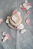 A cake decorated with fondant icing sugar, heart-shaped biscuit and sugar roses
