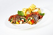 Beef roulade filled with vegetables, tomato sauce and grilled corn cobs