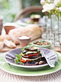 An aubergine tower with olives and mozzarella