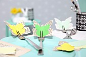 Osterdeko in Gelb-Grün: Schmetterlinge aus Papier an Gabeln befestigt