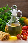 Olive oil, tomatoes, parsley and spaghetti on a wooden table