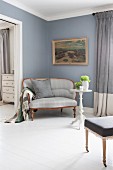 Biedermeier sofa with pale grey cover below antique painting on dove blue wall in elegant interior