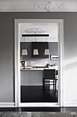 View of kitchen counter through open doorway from elegant foyer with stucco frieze