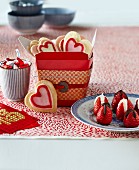 herzförmige Kekse, Schokoladenerdbeeren und Pralinen zum Valentinstag