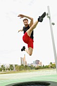 A man trampolining in a park against a skyline