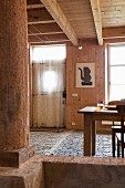 Dining area in renovated house with rustic paved floor and wood cladding