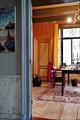 View of desk seen from foyer through open door in renovated house with wood-clad interior