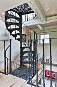 Kunsthandwerkliche schwarze Vintage-Spindeltreppe in rustikalem Landhaus