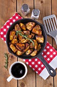 Spiced baked potatoes with rosemary in a cast iron pan