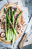 Tarte flambée with green asparagus and onion rings