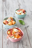 Three bowls of melon salad with mozzarella balls and Parma ham