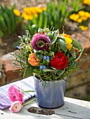 Colourful summer posy of ranunculus in ceramic pot