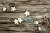 Biscuit cutters, cinnamon stars and cinnamon sticks on the wooden surface